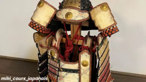 Armure de samouraï japonaise (甲冑, kacchū) avec casque, plaques dorées et cordons rouges.